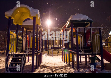 Coperte di neve parco giochi di notte nella città in inverno Foto Stock