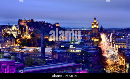 Fotografato subito dopo il tramonto dalla cima di Calton Hill Ottobre 2018 quando il castello illuminato ed edifici lungo Princes Street sono illuminati Foto Stock