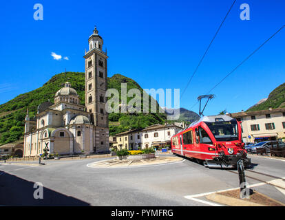 Bernina Express treno in transito vicino al vecchio santuario di Tirano, Valtellina, Lombardia, Italia Foto Stock