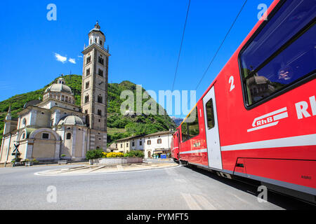 Bernina Express treno in transito vicino al vecchio santuario di Tirano, Valtellina, Lombardia, Italia Foto Stock