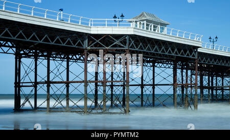 Cromer Pier con onde si fonde con la nebbia a Cromer Beach in Norfolk England Regno Unito Foto Stock