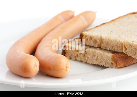 Due cotte frankfurters su una piastra con pane Foto Stock