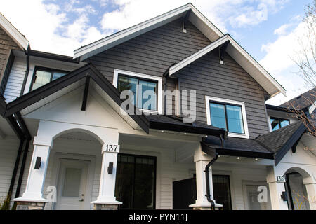 Nuovo di zecca townhouses con pavimentazione in calcestruzzo nella parte anteriore. Lato anteriore del case a schiera sulla giornata di sole in Canada. Foto Stock