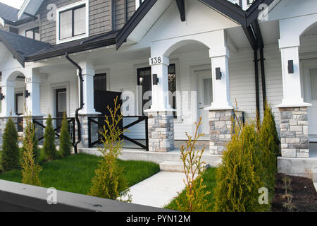 Nuovo di zecca townhouses con pavimentazione in calcestruzzo nella parte anteriore. Lato anteriore del case a schiera sulla giornata di sole in Canada. Foto Stock