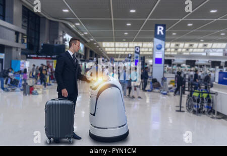 Smart la tecnologia robotica concetto, il passeggero seguire un robot di servizio ad un contatore il check-in in aeroporto, il robot è in grado di aiutare e dare alcune informazioni Foto Stock