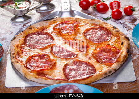 Appetitosi salumi italiani la pizza con ingredienti intorno Foto Stock