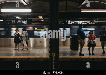 New York, Stati Uniti d'America - 2 Giugno 2018: persone in piedi sulla quattordicesima strada alla metropolitana di New York, movimento del treno sullo sfondo. Metropolitana di New York è uno di t Foto Stock