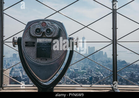 New York, Stati Uniti d'America - 29 Maggio 2018: a gettone binocolo sulla piattaforma di osservazione a Empire State Building, New York, USA, città sullo sfondo. Esso Foto Stock