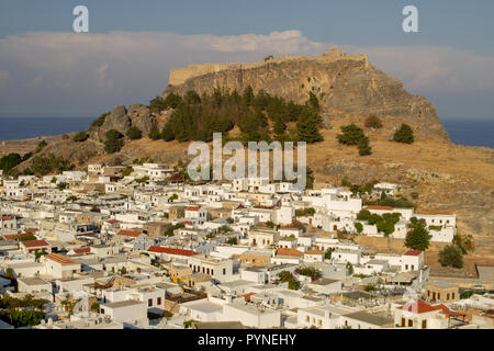 The whitewashed buildings of the village of Lindos,Rhodes,Greece dominated by the ancient Acropolis parts of which date back to 280 B.C. Foto Stock