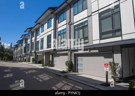 Nizza sviluppo di nuove case a schiera. Righe di townhomes fianco a fianco. La facciata esterna di una fila di coloratissimi urbana moderna townhouses. nuove case jus Foto Stock