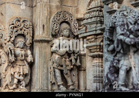 Intricate sculture di divinità Indù e Puranic storie a Belur e Halebid tempio premessa. Belur, Karnataka, India. Foto Stock