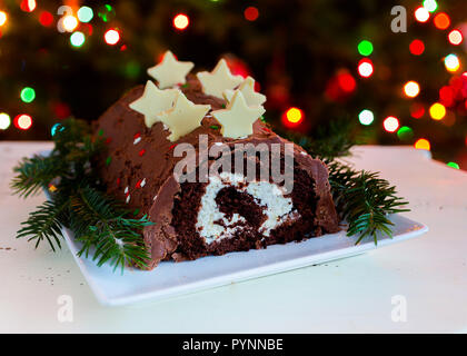 Yule log nella parte anteriore di un albero di Natale. Foto Stock