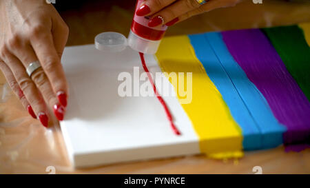 Artista femminile dipinto un arcobaleno con colori acrilici su tela, hoe arte, DIY tutorial, colorato Foto Stock