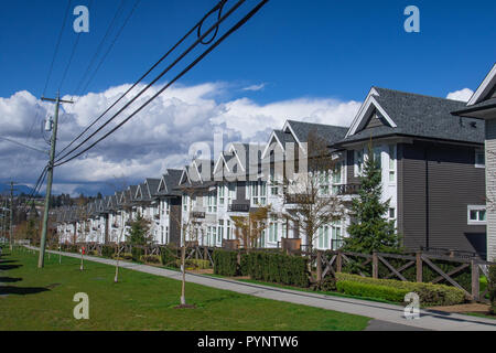 Suburban strada residenziale townhomes. In bright soleggiata giornata di primavera contro il blu intenso del cielo. Foto Stock