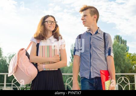 Gli adolescenti studenti con zaini, libri di testo, andare a scuola. Outdoor ritratto di ragazzo adolescente e ragazza 14, 15 anni. Foto Stock