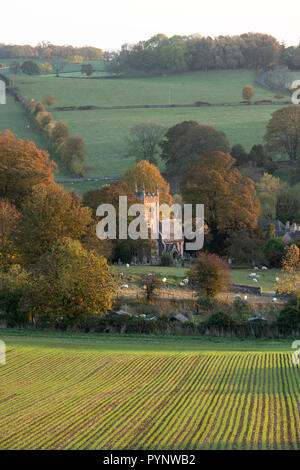 Autunno mattina all'alba Affacciato sulla chiesa di St Peters in Upper Slaughter. Cotswolds, Gloucestershire, Inghilterra Foto Stock