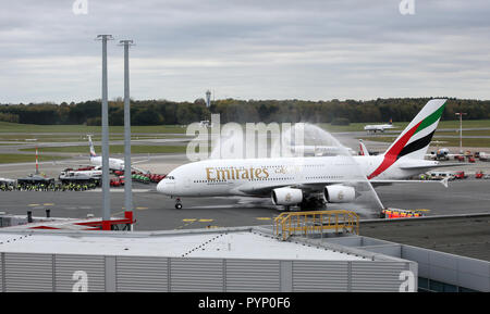 Amburgo, Germania. 29 ott 2018. Un Emirates Airbus A380 che vengono accolti a Helmut Schmidt Aeroporto con fontane di acqua da due motori fire. La compagnia aerea ha iniziato voli di linea ad Amburgo con l'aeromobile Airbus A380. Credito: Bodo segna/dpa/Alamy Live News Foto Stock