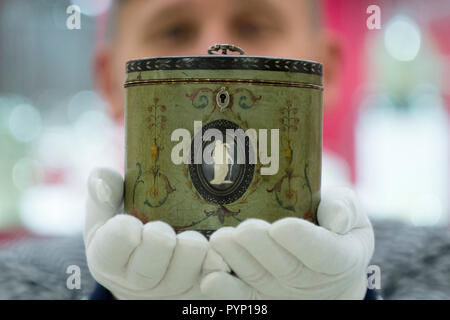 Londra, Regno Unito. Il 29 ottobre 2018. Il concessionario presenta 'una Henry Clay policromo tè ovale caddy nel modo di Robert Adam', circa 1785, al Winter Arts & Antiques Fair a Olympia. 70 dei migliori del Regno Unito sono i concessionari che vendono di tutto, dai diamanti per tavoli da pranzo e da orologi di ceramica. La mostra durerà fino al 4 novembre 2018. Credito: Stephen Chung / Alamy Live News Foto Stock