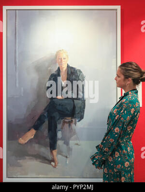 Olympia Exhibition Centre di Londra, UK, 29 ott 2018. Una galleria assistant dall arte commissioni guarda un commissionato ritratto dipinto da Rosalie Watkins. L'inverno arte e antiquariato a Olympia London correrà Ott 30-Nov 4. Credito: Imageplotter News e sport/Alamy Live News Foto Stock