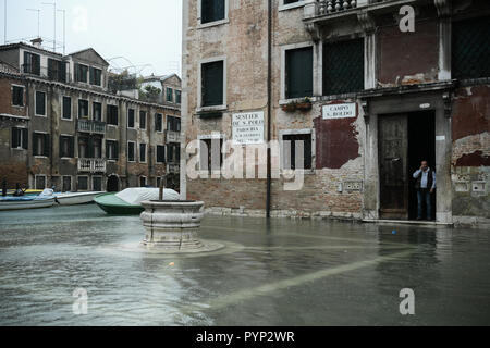 Venezia, Italia. 29 ottobre, 2018. Un uomo guarda su dalla sua residenza durante un eccezionale Acqua Alta - Alta Marea inondazioni in Venezia, Italia il 29 ottobre 2018. Il 70% della città lagunare è stata inondata dalle acque rising 149 centimetri sopra il livello del mare. Credito: Piero Cruciatti/Alamy Live News Foto Stock