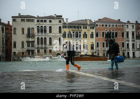 Venezia, Italia. 29 ottobre, 2018. I turisti che indossa wellies a piedi durante un eccezionale Acqua Alta - Alta Marea inondazioni in Venezia, Italia il 29 ottobre 2018. Il 70% della città lagunare è stata inondata dalle acque rising 149 centimetri sopra il livello del mare. Credito: Piero Cruciatti/Alamy Live News Foto Stock