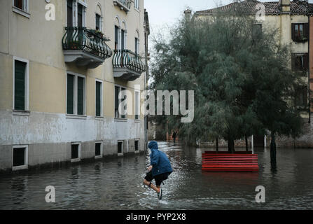 Venezia, Italia. 29 ottobre, 2018. Un giovane ragazzo passeggiate in Acqua alta eccezionale durante l'Acqua Alta - Alta Marea inondazioni in Venezia, Italia il 29 ottobre 2018. Il 70% della città lagunare è stata inondata dalle acque rising 149 centimetri sopra il livello del mare. Credito: Piero Cruciatti/Alamy Live News Foto Stock