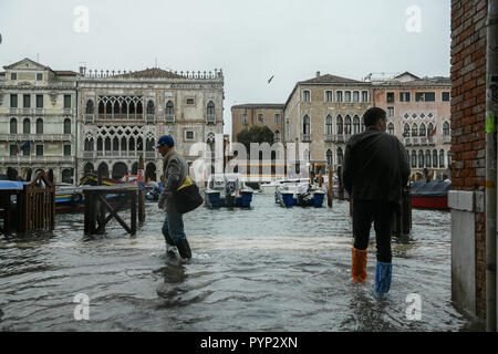 Venezia, Italia. 29 ottobre, 2018. La gente che indossa la pioggia wellies a piedi in acqua durante un eccezionale Acqua Alta - Alta Marea inondazioni in Venezia, Italia il 29 ottobre 2018. Il 70% della città lagunare è stata inondata dalle acque rising 149 centimetri sopra il livello del mare. Credito: Piero Cruciatti/Alamy Live News Foto Stock