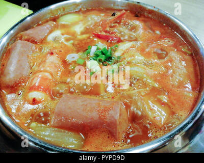 Delizioso cibo Coreano Yukgaejang piccante zuppa di pesce, Yukgaejang Hot pot è il Coreano stufato preparato con kimchi, tagliatelle, prosciutto, salsiccia, cozze, gamberi e verdura Foto Stock