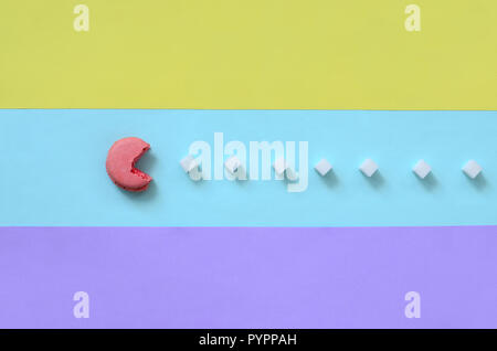 Una composizione di amaretto con una bocca aperta che sta andando a mangiare zollette di zucchero su un blu, rosa, giallo e viola lo sfondo color pastello. Il concetto di vecchio Foto Stock