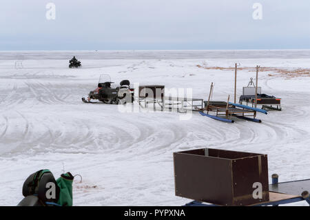 Nida, Lituania, 10 marzo 2018, i pescatori sul ghiaccio pronto per andare in slitta elettrico più lontano dalla riva, motoslitte per la pesca invernale Foto Stock