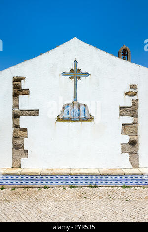 Croce fatta di azulejos su una parete della cappella, Ericeira, costa di Lisbona, Portogallo Foto Stock