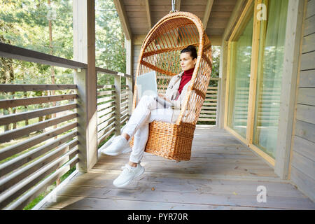 Malinconici lady freelancer lavorando sul balcone Foto Stock