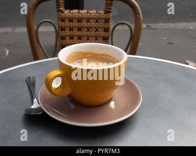 Vista del caffè giallo Tazza da caffè nella parte anteriore della sedia in legno Foto Stock