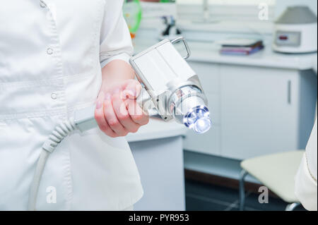 Medico è in possesso di una moderna attrezzatura medica per la pelle del viso Trattamento, close up Foto Stock