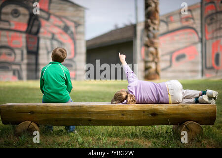 Due bambini seduti su una panca in legno. Foto Stock