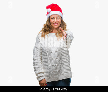 La mezza età senior donna ispanica con cappello a Natale su sfondo isolato sorridente cordiale offrendo stretta di mano come saluto e accogliente. Successo Foto Stock