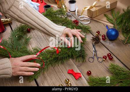 Donna che fa ghirlanda di Natale Foto Stock