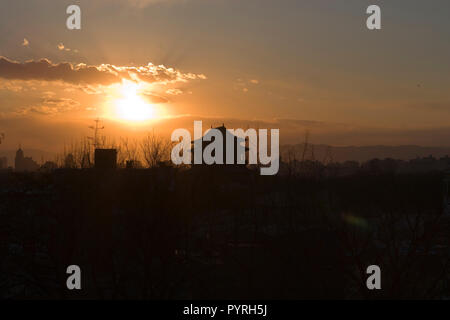 Impostazione di Sun nel corso di una città scape. Foto Stock