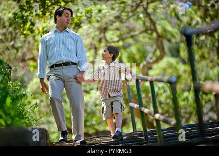 Felice di padre e figlio a piedi giù per le scale in un parco. Foto Stock