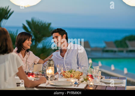 Amici gustando una cena all'aperto sul loro retro deck. Foto Stock