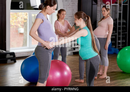 Donne in stato di gravidanza facendo esercizio in classe di fitness Foto Stock