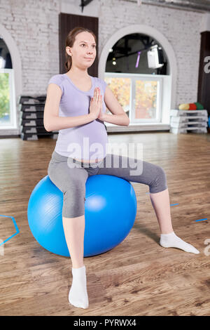 Donna incinta facendo Yoga prenatale Foto Stock