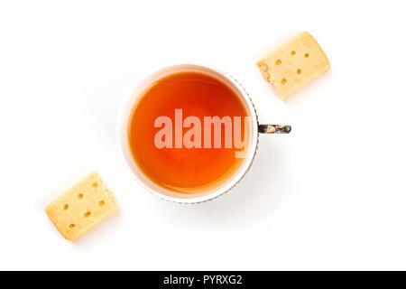 Un overhead foto di due pezzi di pastafrolla scozzese burro cookie, ripresa dall'alto su un fondo bianco con un vintage tazza di tè, con spazio di copia Foto Stock