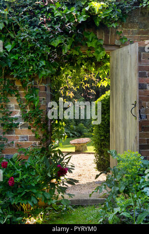 Porta in legno nella parete che conduce al Giardino Inglese,l'Inghilterra,l'Europa Foto Stock