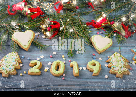 Vetri di Natale gingerbread cookies e le decorazioni di Natale in blu sullo sfondo di legno Foto Stock