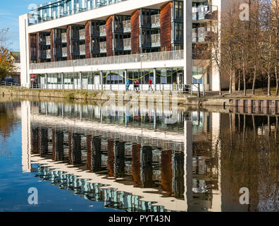 Moderno blocco di appartamenti su Riverside, Riva, Leith, Edimburgo, Scozia, Regno Unito con la riflessione nel fiume di acqua di Leith Foto Stock