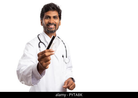 Medico indiano uomo mostra carta di debito o di credito con allegro trustworthy espressione isolato su sfondo bianco Foto Stock