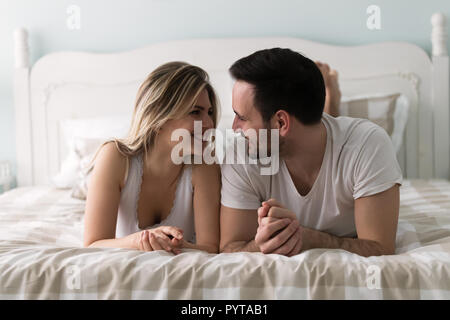 Giovane coppia attraente avente tempo di romantico nel letto Foto Stock