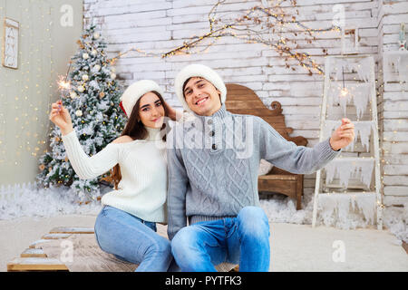 Felice coppia giovane indossando cappelli di Babbo Natale il divertimento a Natale. Foto Stock