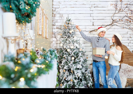 Felice coppia giovane indossando cappelli di Babbo Natale il divertimento a Natale. Foto Stock